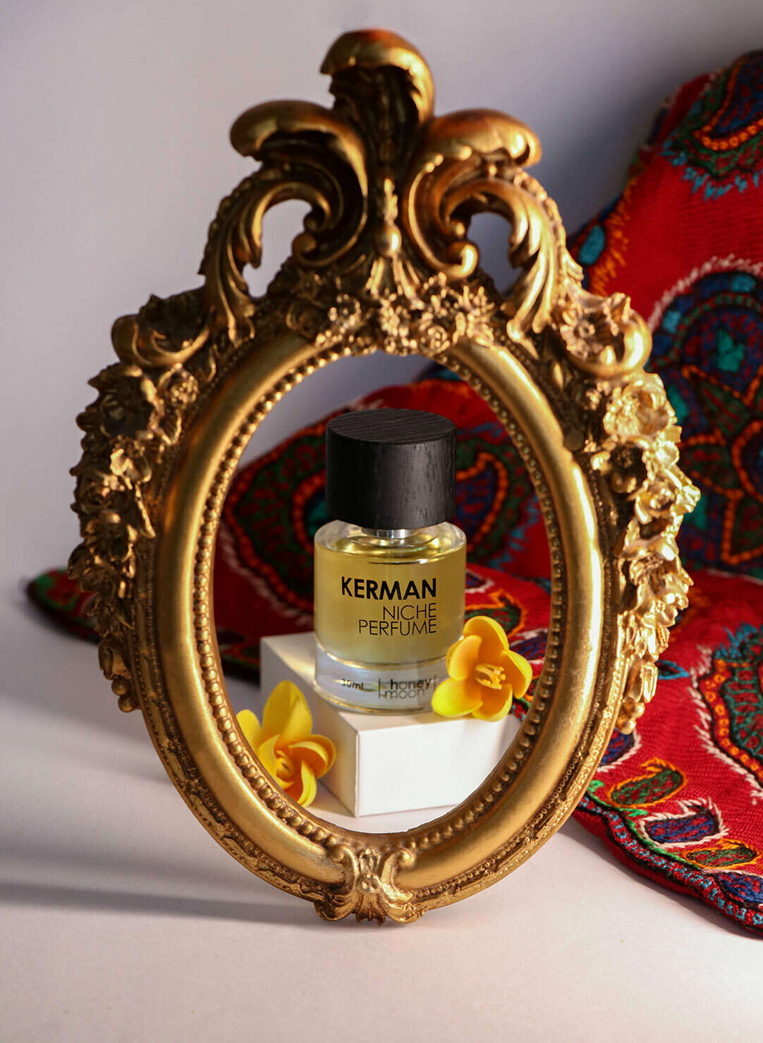 عطر کرمان در یک قاب در کنار پته صنایع دستی این شهر